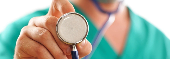A close-up of a healthcare professional holding a stethoscope toward the viewer